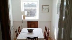 A dining area with a table, chairs, a window, and a fireplace. - Sea View Apartment with commanding sea views in Crail (Crail)
