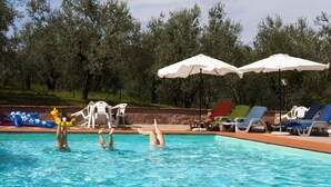 Une piscine équipée de chaises longues et de parasols.