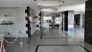 A modern lobby with a marble floor, a reception desk, and a glass wall. - Amazing Nile View & Pyramids (Cairo)