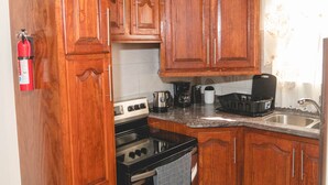 Cucina con mobili in legno, un fornello e un lavello.
