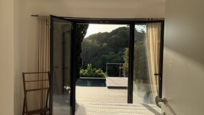 Ein Schlafzimmer mit einer großen Schiebeglas-Tür, die auf einen Balkon führt.