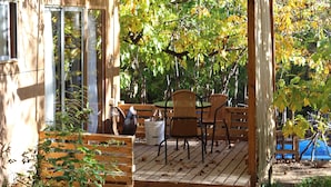 Eine Holzterrasse im Freien mit einer Pergola, einem Tisch und Stühlen.