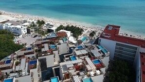 Un resort con varias piscinas, acceso a la playa y vistas al océano.