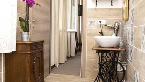 A bathroom with a wooden cabinet, a sink, and a toilet.