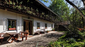 Un bâtiment traditionnel doté d’un balcon, d’un espace extérieur aménagé pour s’asseoir et d’un jardin.