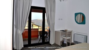 A room with a sliding glass door leading to a balcony, a desk with a chair, and a radiator. - Apartment "Luna Nuova" (Tusa)
