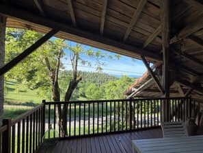 Una terraza de madera con vistas a un bosque y montañas.