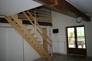 Staircase leads to an upper level, with a window offering a view of the outdoors.