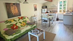 A living room with a sofa, a coffee table, and a dining area with chairs and a table.