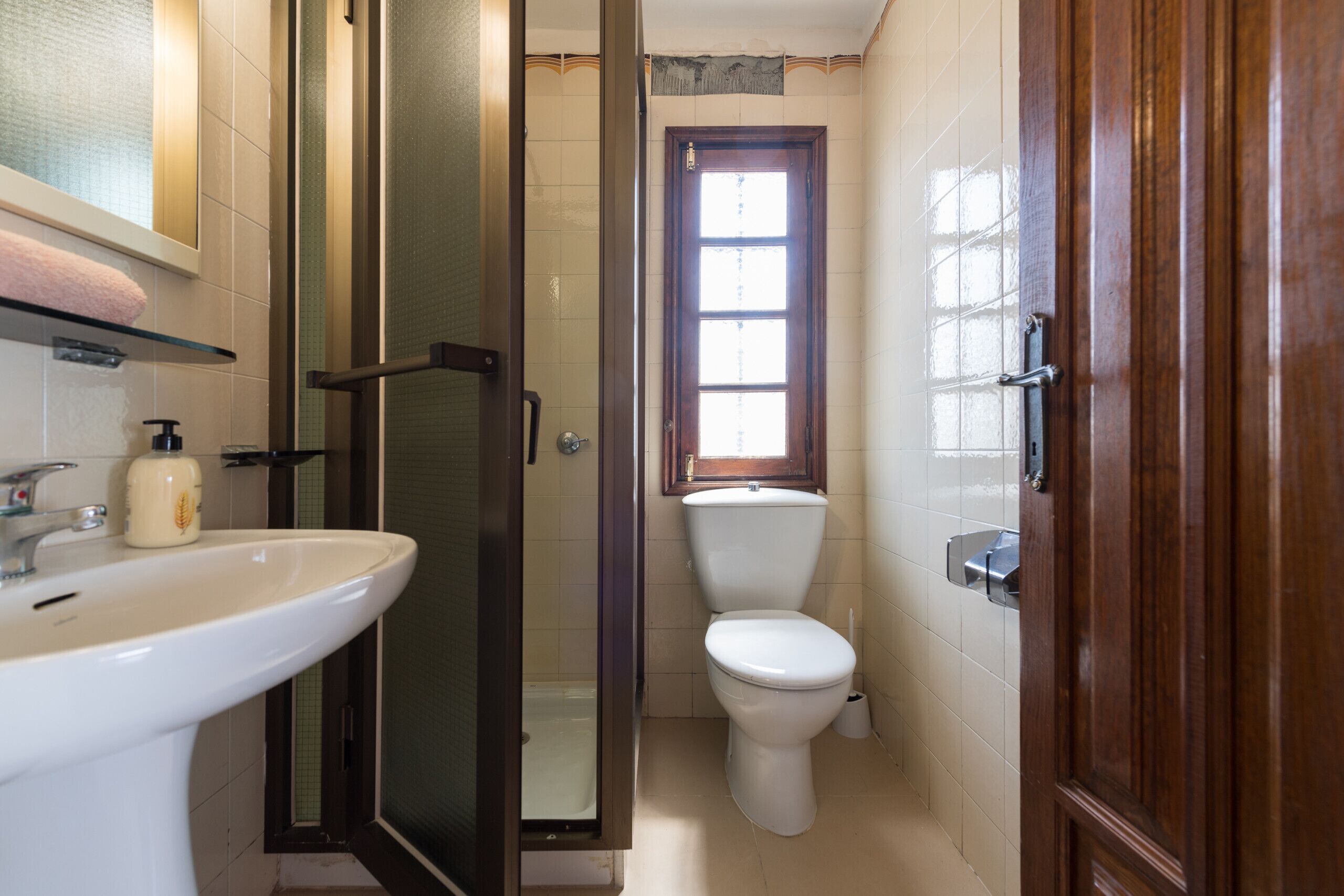A bathroom with a sink, toilet, and glass shower enclosure.