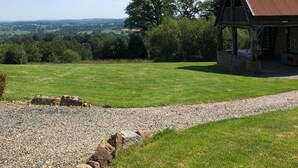 A rustic barn with a metal roof, surrounded by a well-maintained lawn and a gravel path leading to it. - SPACIOUS Family Farmhouse in 3 ACRES with STUNNING VIEWS, EXCLUSIVE USE. (Sourdeval)