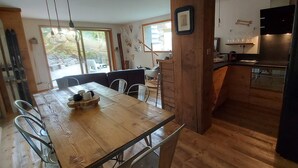 A spacious kitchen with a wooden table and chairs, a dining area with a view, and a modern kitchen area with a stove and sink. - Vars. Full-service center.  Private parking. Linens provided, beds made. (Vars)
