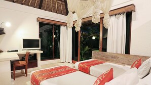 A hotel room with a large bed, a desk with a TV, and a view of the outdoors.