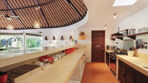A kitchen with a curved ceiling, a central island, and a view of the outdoors.