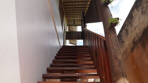 A wooden staircase with a metal railing and a view of the sky.