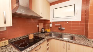A kitchen with granite countertops, stainless steel appliances, and wooden cabinets. - DESCONNECTAR - Tossa de Mar (Tossa de Mar)