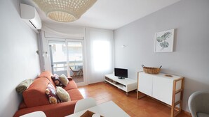 A modern living room with a sofa, TV, and a small table with a tray. - DESCONNECTAR - Tossa de Mar (Tossa de Mar)