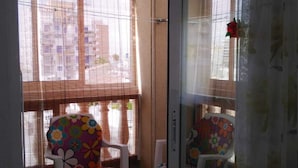 A room with a glass door leading to a balcony with two chairs and a window with blinds. - Beautiful apartment in Torrevieja (Torrevieja)