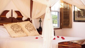 Un dormitorio con cama con dosel, cabecera de madera y mesita de noche con lámpara.