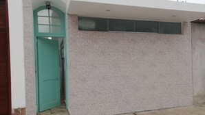A modern building with a teal door and a garage door.