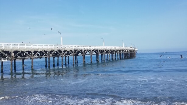 A pier extending into the water with a clear sky above.