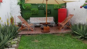 A patio area with a covered seating area, a small table, and a decorative umbrella.