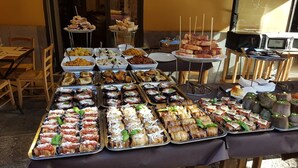 Ein reichhaltiges Buffet mit verschiedenen Speisen, darunter Brot, Salate und Desserts.