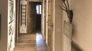 A hallway with wooden floors, wooden doors, and a mounted antler on the wall. - Les Arcs skiing: Charming chalet in an idyllic location minutes from chair lift (Villaroger)