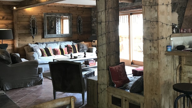 A rustic interior with exposed wooden beams, a wooden table, and a sofa with cushions. - Les Arcs skiing: Charming chalet in an idyllic location minutes from chair lift (Villaroger)