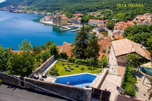 A villa with a swimming pool, a view of the sea, and a courtyard with lounge chairs. - Villa Volcera *****  (Bakar)