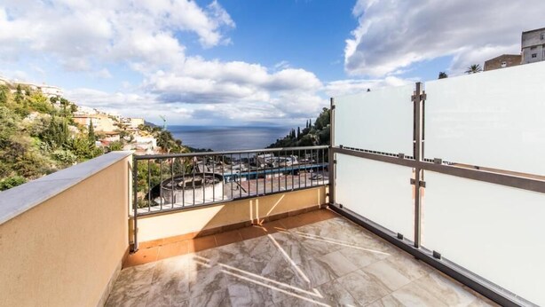 Une terrasse sur le toit offrant une vue sur la mer et les collines environnantes.