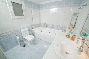 Bañera con ducha, secador de pelo, toallas, shampoo