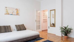 Een moderne slaapkamer met een bed, een kaart als kunstwerk aan de muur, een spiegel en een potplant.