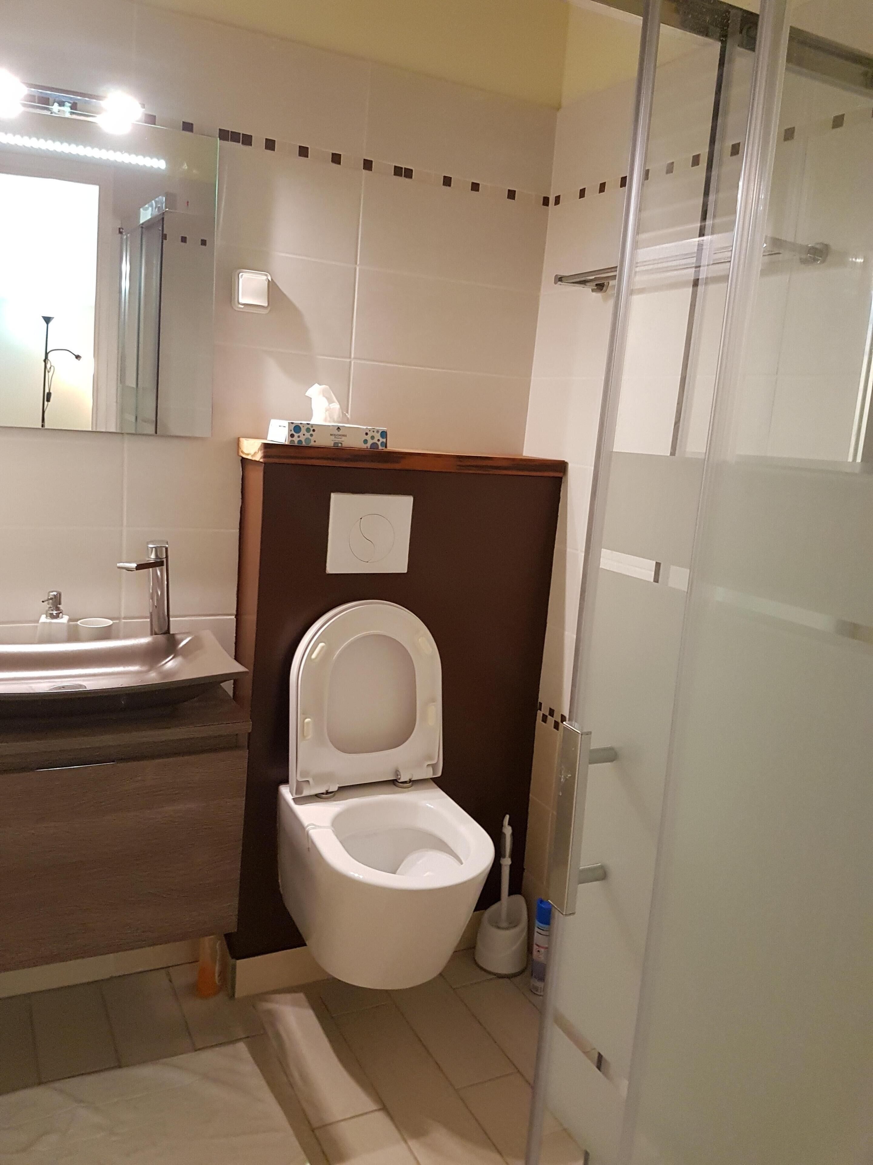 Un baño con inodoro, lavabo y espejo.