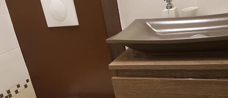 A bathroom with a toilet, a bidet, a sink, and a mirror.