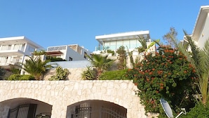 A modern building with a stone archway, a balcony, and a view of the sky.