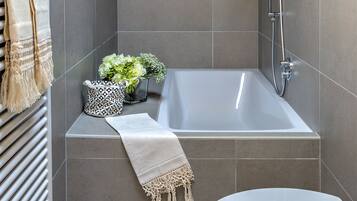 Un bagno moderno con vasca, WC e doccia.