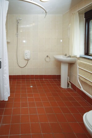 Un baño con ducha, lavamanos e inodoro.