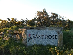 A stone sign with the text "EAST ROSE" and a pink flower symbol.