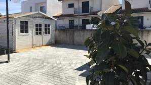 Ein Basketballfeld mit Korb, eine kleine Hütte und ein Haus mit Ziegeldach.