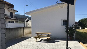 Eine Terrasse mit Picknicktisch, Basketballkorb und einer Topfpflanze.