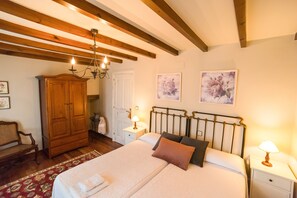 Camera da letto con un letto grande, un'armadio in legno e un lampadario.