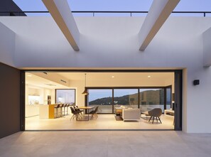 Un interior moderno con comedor, cocina y zona de estar con vistas.