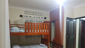 Una habitación con literas, un armario y una puerta.