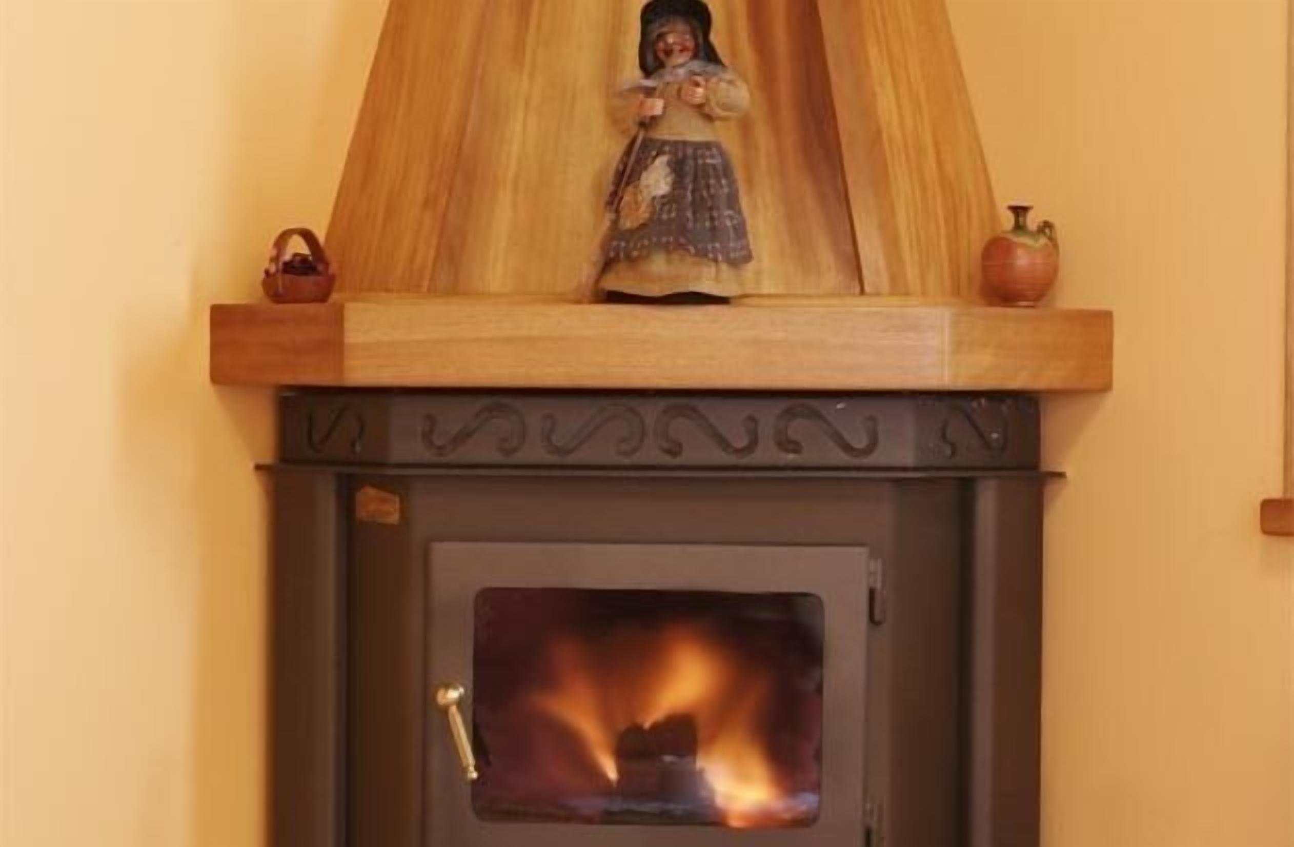 A wood-burning stove with a decorative figure above it.