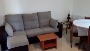 A living room with a grey sofa, a wooden coffee table, a glass table, and a chair. - holiday home in galdames (galdames,vizcaya)