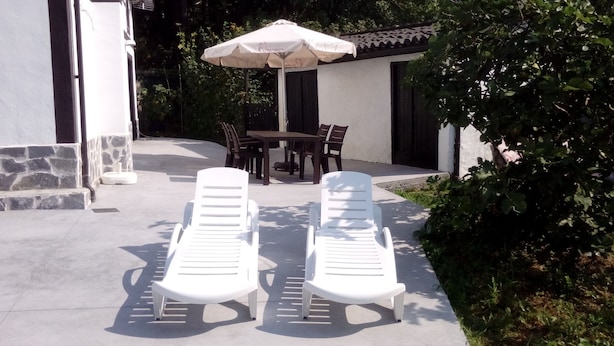 Two white lounge chairs and a table with a white umbrella in an outdoor patio area. - holiday home in galdames (galdames,vizcaya)