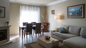 Ein Wohnzimmer mit Kamin, Esstisch und Sofa.
