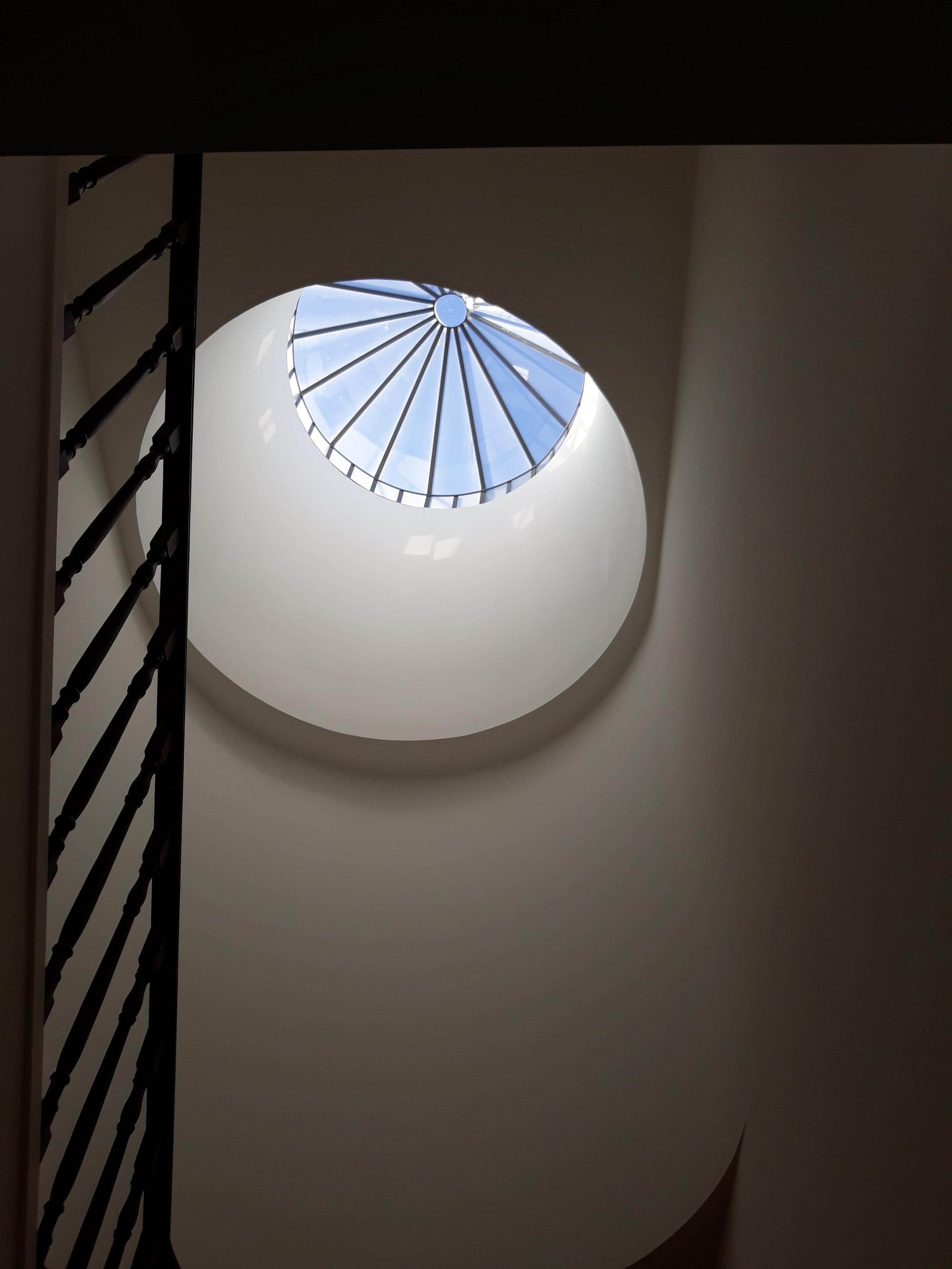 A circular skylight with a radial design, allowing natural light to enter a room.
