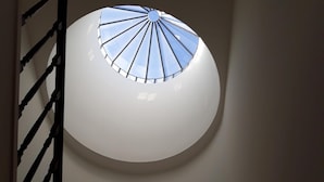 Un oculi circular amb un disseny radial que deixa entrar llum natural a una habitació.